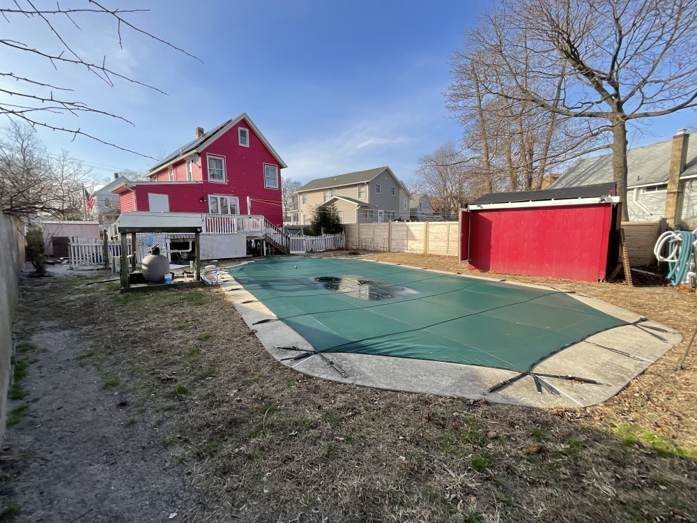 A beach house with green pool.