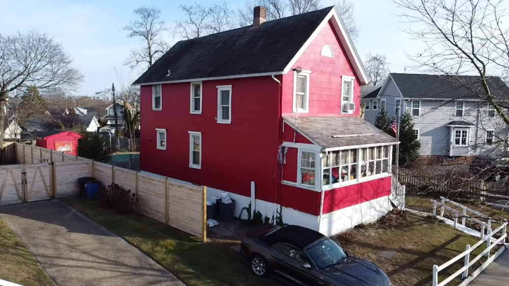 A classic red house with a white picket fence.